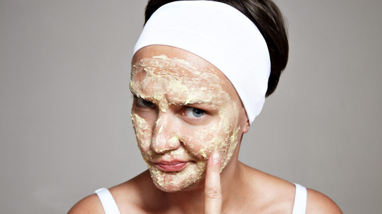 a woman looking suspiciously into the camera as she is not sure if face scrubs are good for skin or not