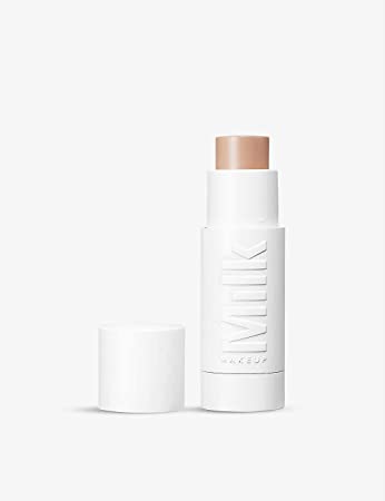 foundation stick with its cap on the lest in front of a white background