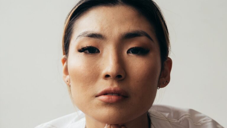 an asian woman posing boldly in front of the camera with concealer and foundation on