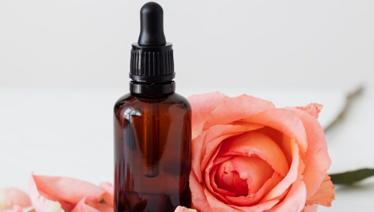 rose flower alongside the essential oil Frankincense used as anti-aging serum