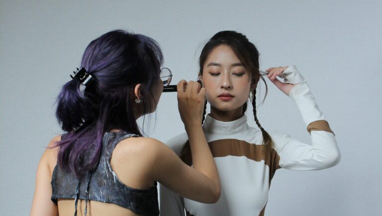 a woman applying foundtion on another womans face to help with her foundation separating at the nose