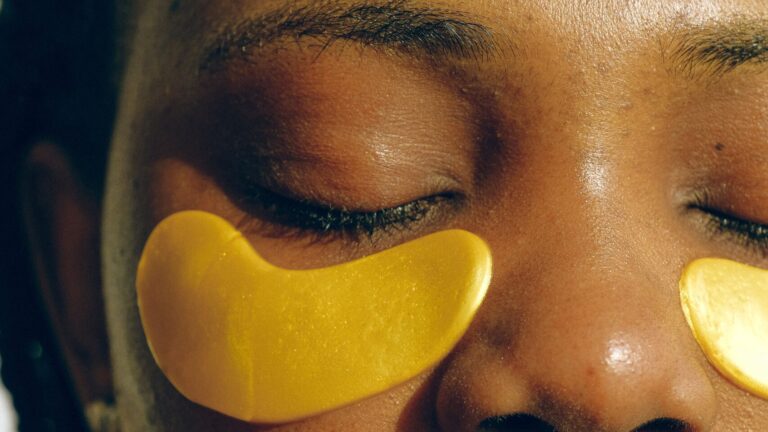 closeup of a woman's eyes as she has applied yellow under eye mask