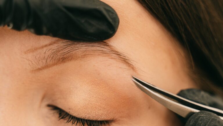 woman getting her eyebrows tweezed for eyebrow filler