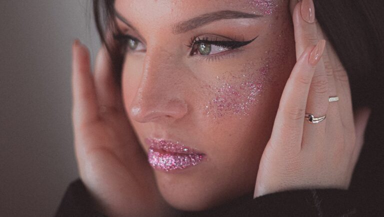 a model wearing glitter lip gloss posing in front of a camera