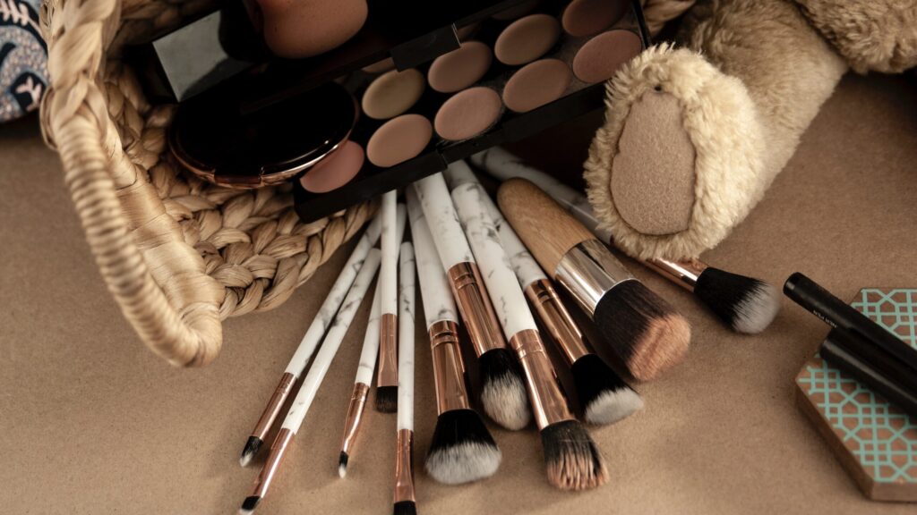 concealers, powders and makeup brushes all placed on a table