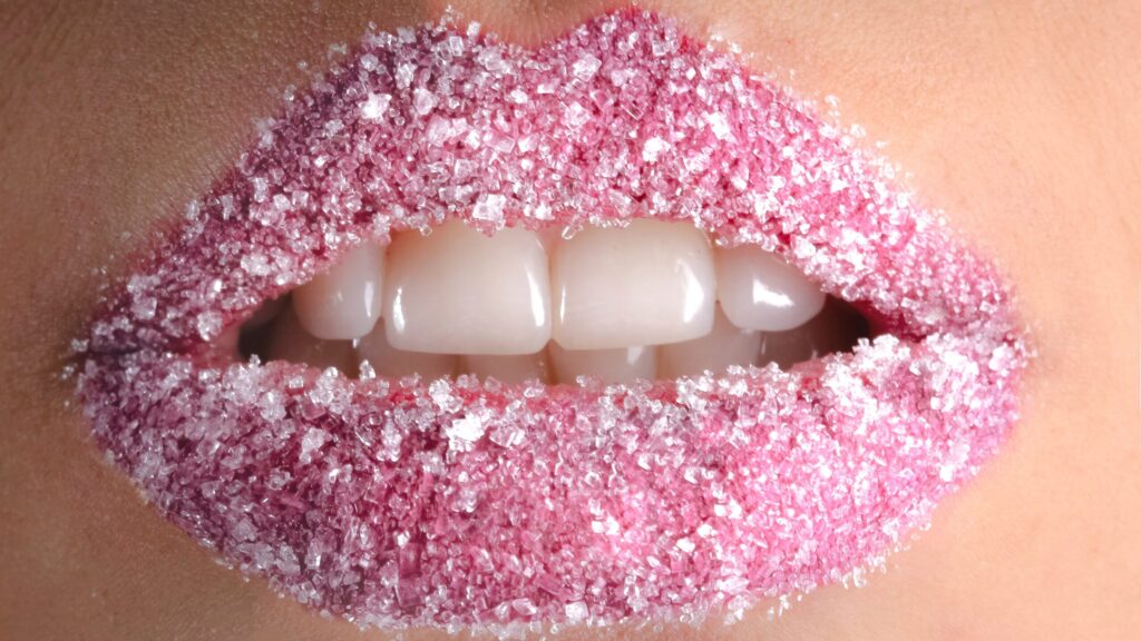 close up of lips with pink lip gloss as the lip gloss leaves a white residue