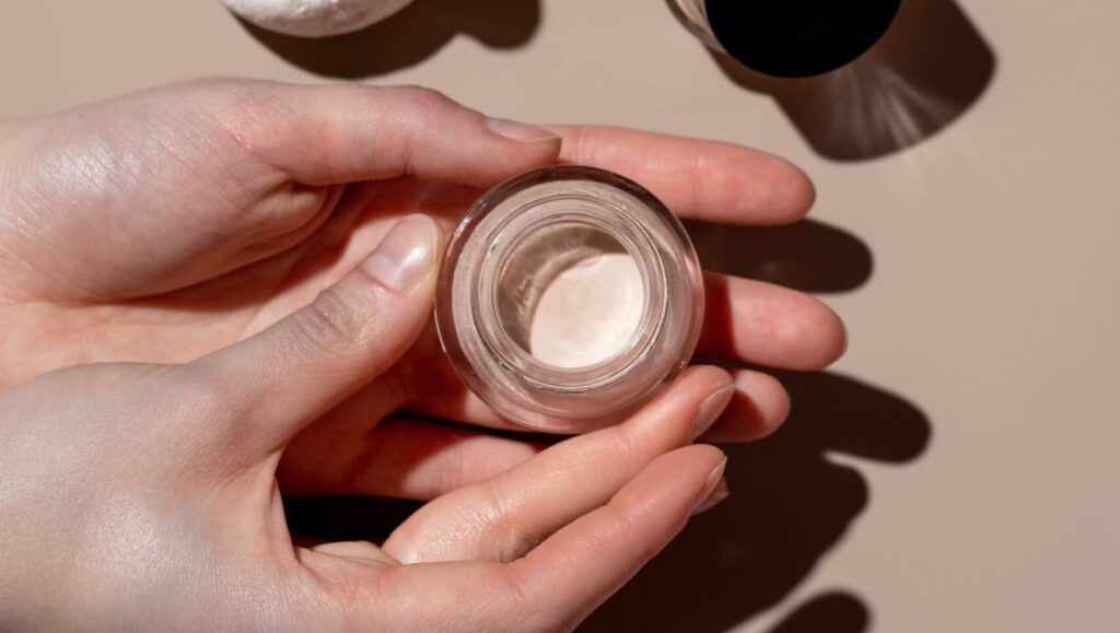 woman holding a concealer in both of her hands.