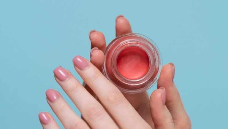 two hands holding lip gloss in a container