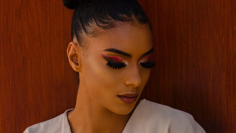 an afro woman posing in front of camera as she shows off her magnatic eyelashes