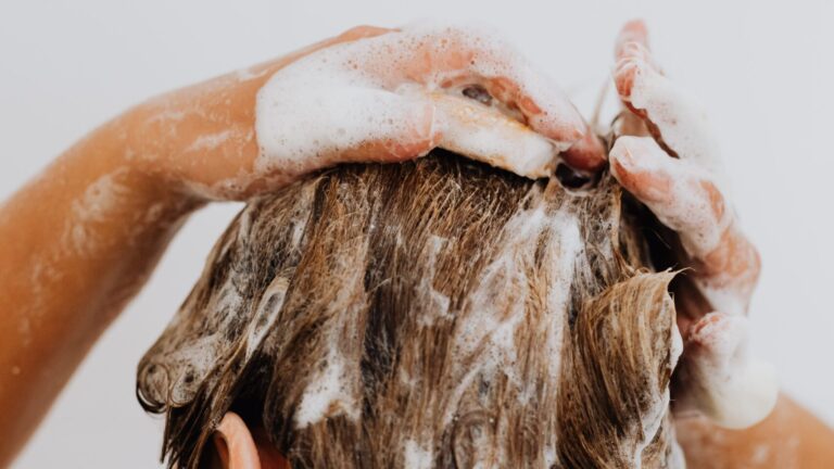 a woman shampooing her oily scalp