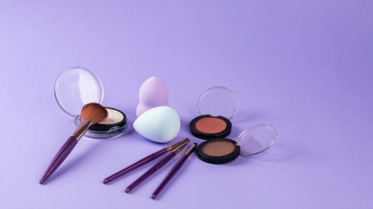 beauty blenders, makeup brushes and blushes; all placed on a purple background.