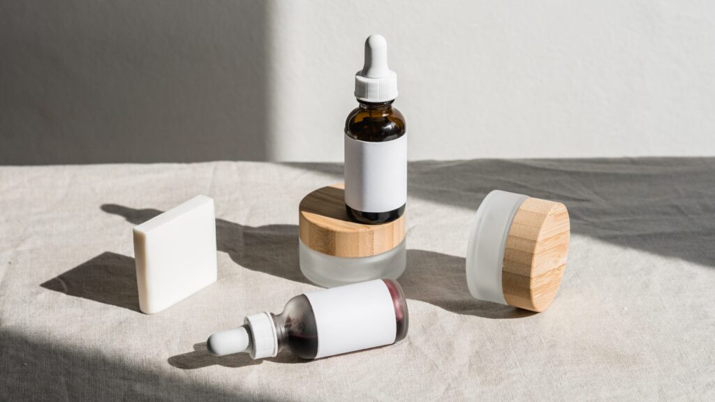 Acne Serums and containers placed on a white table as son light hits them from a 45 angle