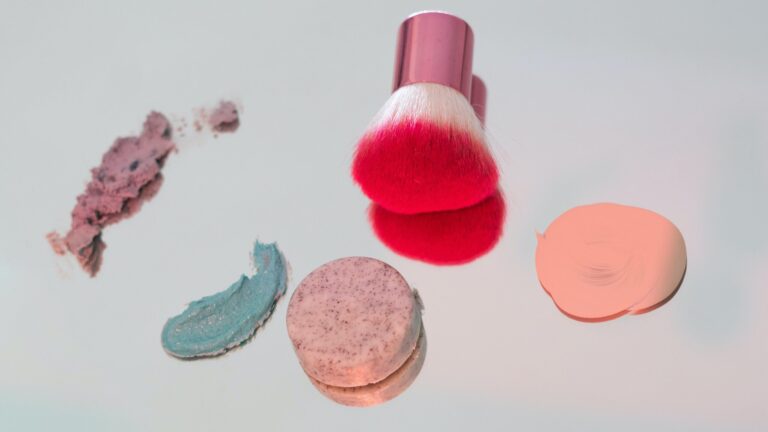 a beauty blender with swatches of foundation placed on a mirror.