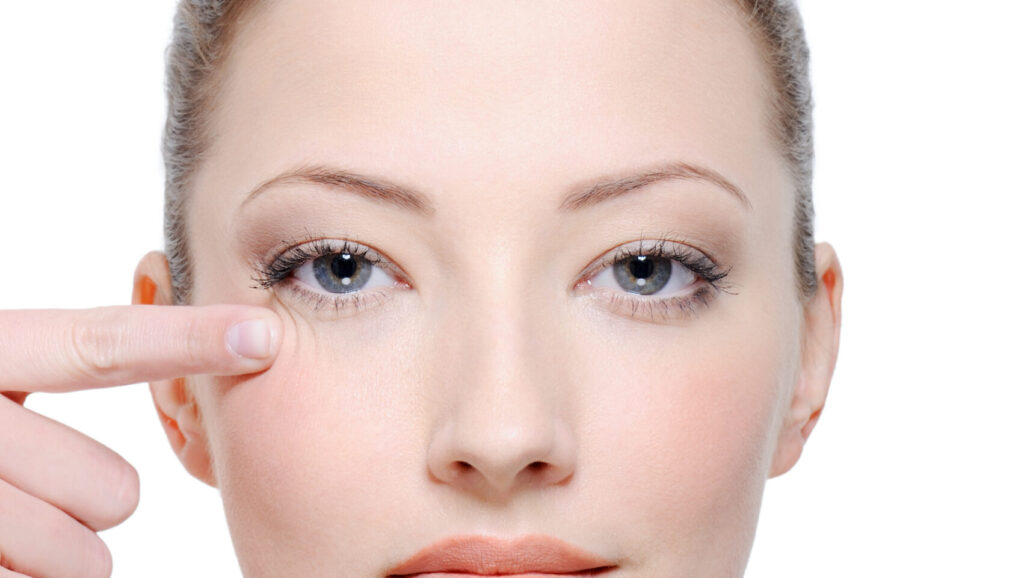 photo of a woman after getting under-eye fillers in front of a white background