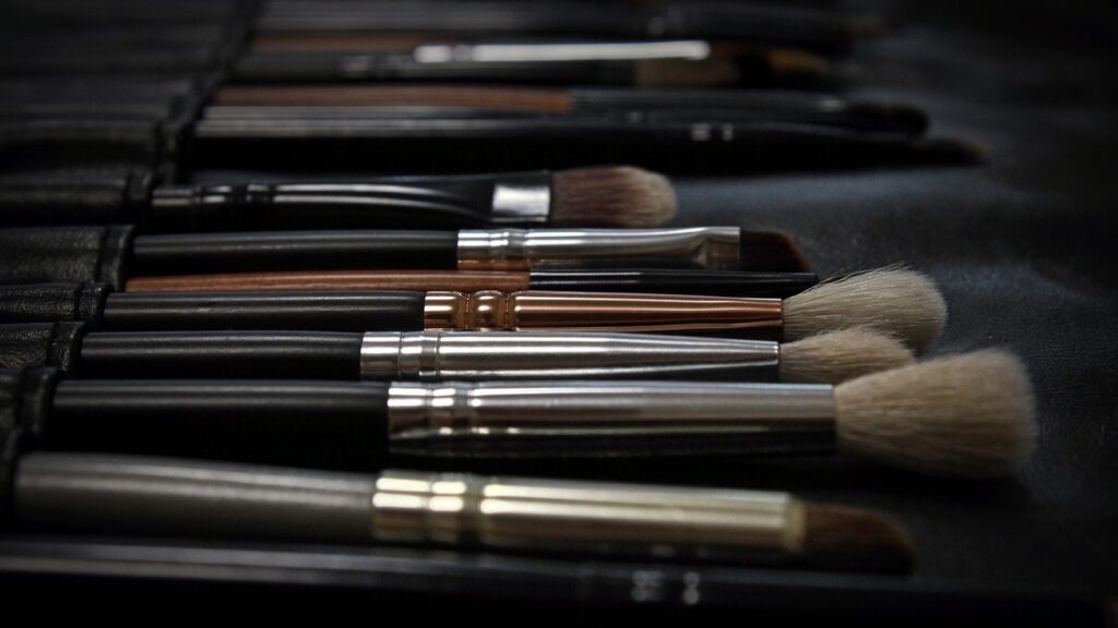 makeup brushes all aligned placed on a back surface