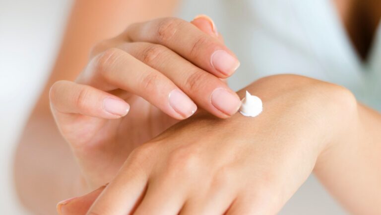 Lady applying moisturizer to prevent hands getting dark in winters