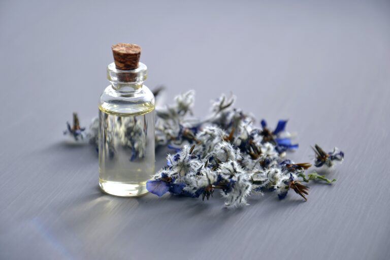 A lavender flower next to a bottle of body mist