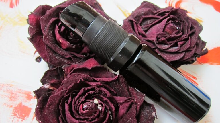 rosewater spray in a black container placed on three roses