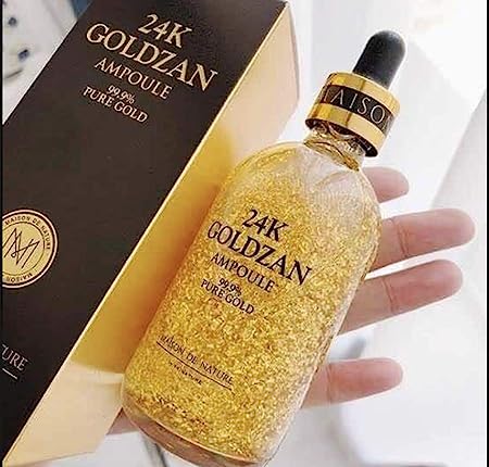 a hand holding a bottle of 24k GOLDZAN Pure Gold Serum