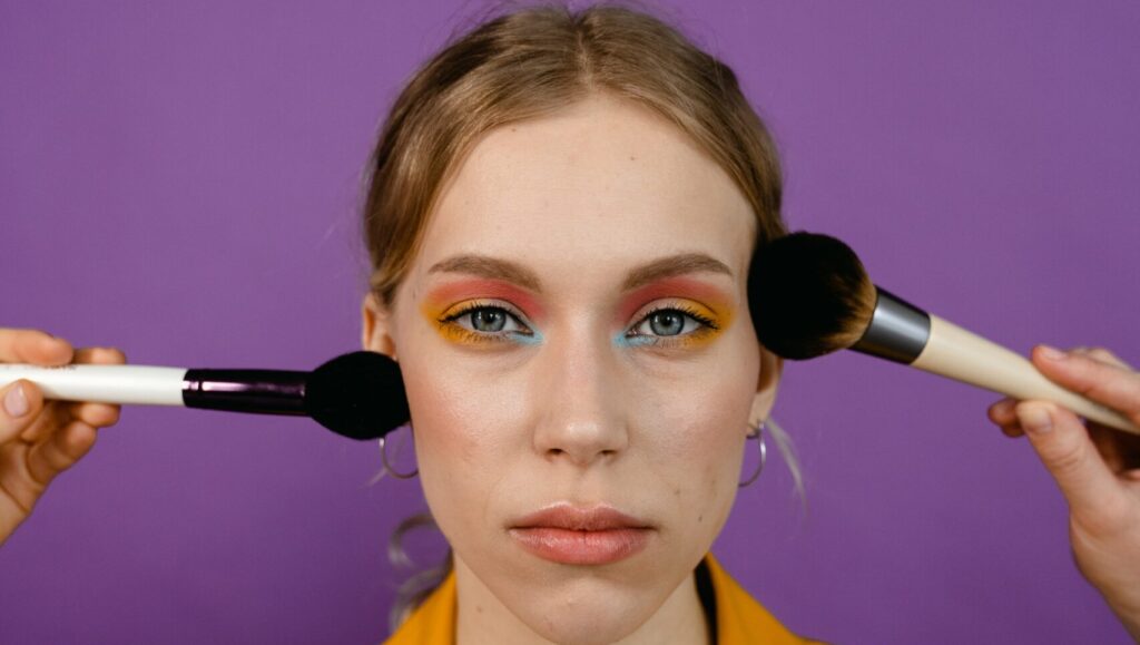 portrait of a pleasant looking woman using Stippling Makeup Brush to apply makeup on her face