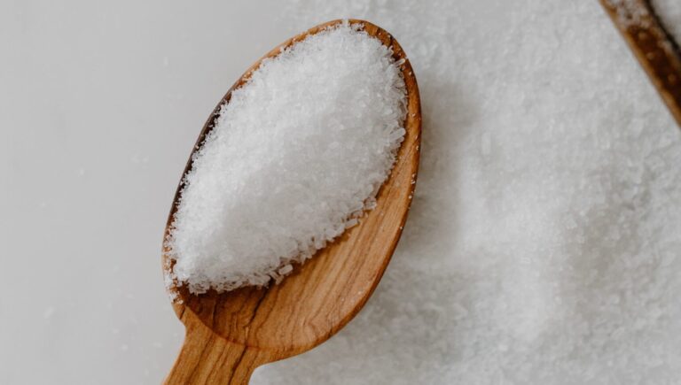 a wooden spoon with salt scrub in it