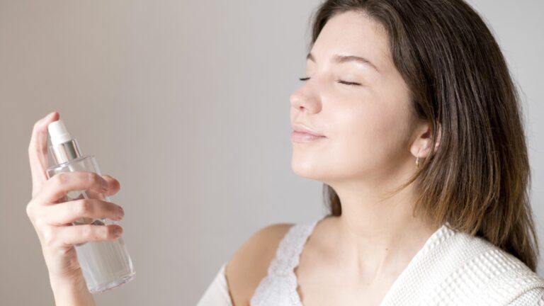 side view of a woman applying micellar water spray on her face