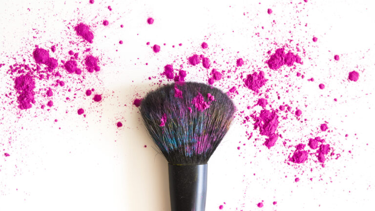 top view makeup brush covered in pink face powder