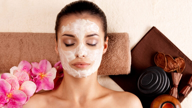 Young woman relaxing with face scrub on face